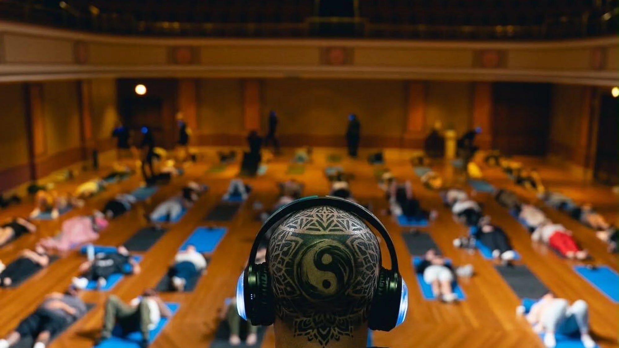 Garry Wright overlooking a group breathwork session, with his yin-yang tattoo visible